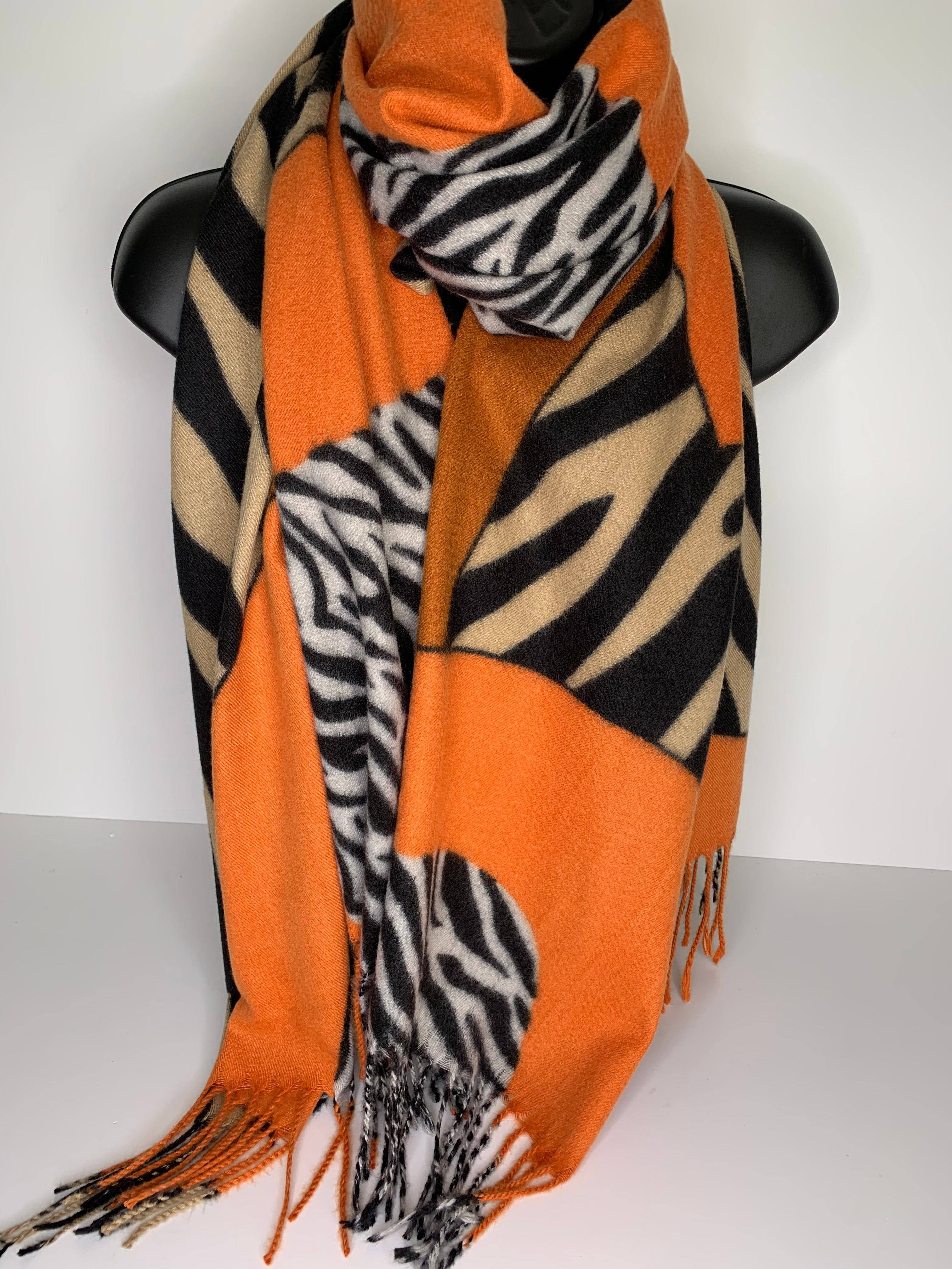 Winter weight, cashmere-mix zebra print scarf in shades of orange, tan, black, beige and cream