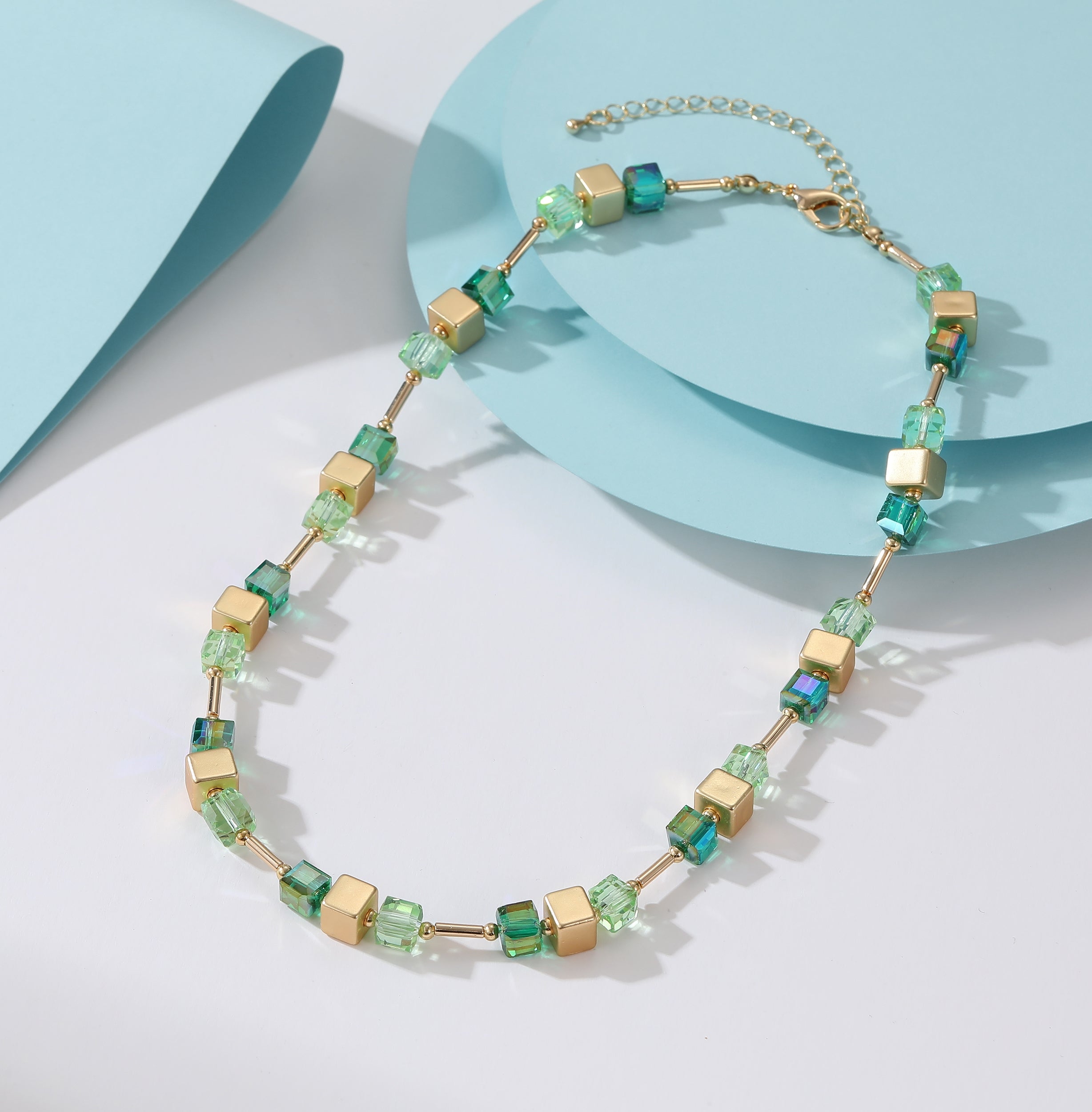 Short necklace with gold chain and aqua blue, gold and light green natural stone stations