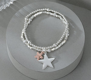 Elasticated bracelet in silver & gold, with two-row star pendant