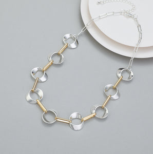 Short necklace, with shiny silver interlinked circles and gold fasteners - on a silver chain
