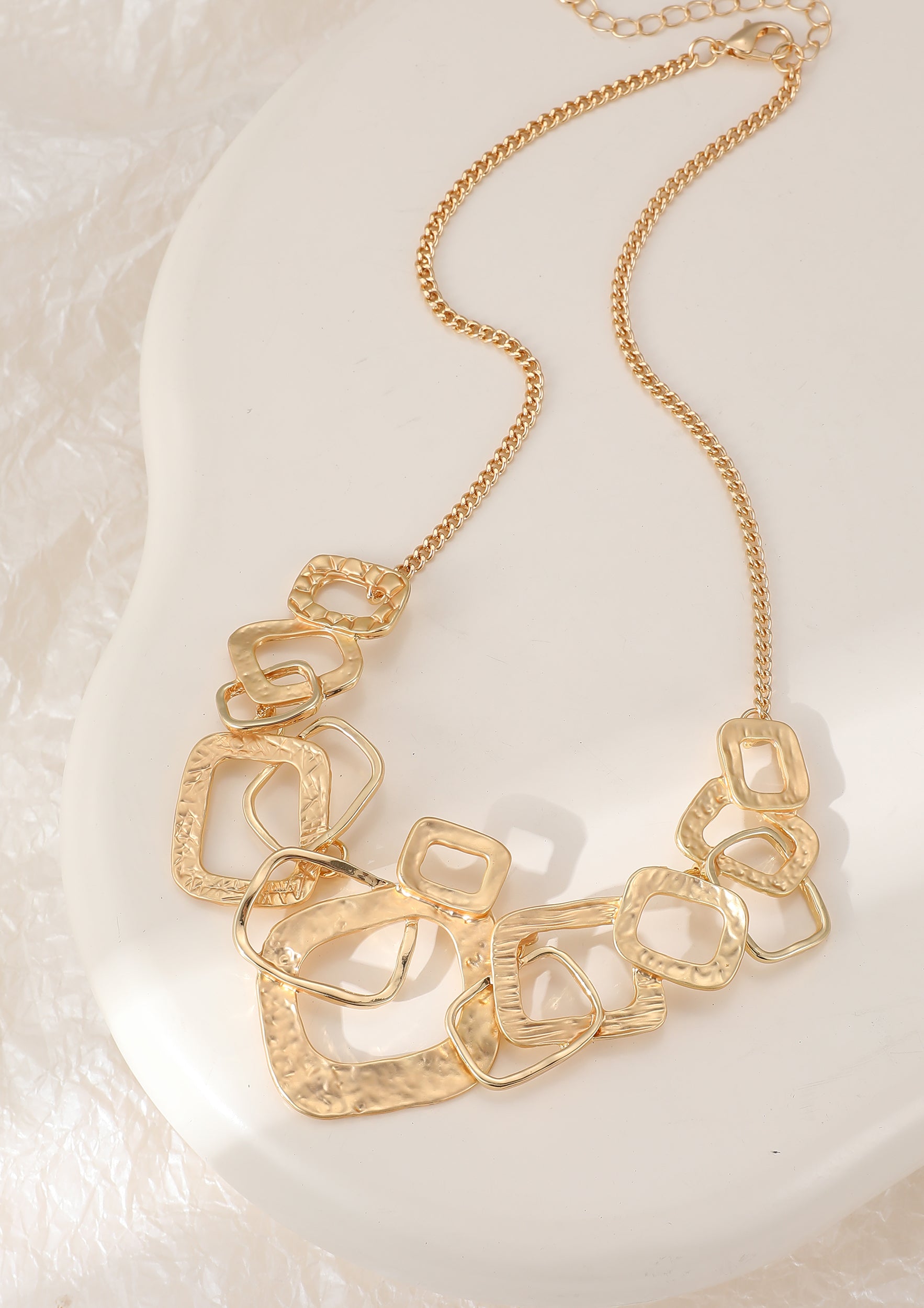 Short necklace, with yellow gold, battered metal interlinked squares