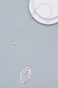 Long necklace, with battered silver metal open-leaf pendant - on a silver chain