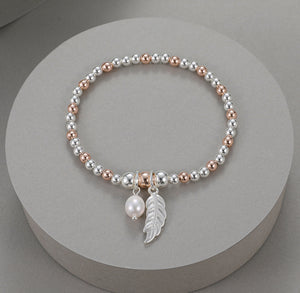 Elastic bracelet with feather and pearl pendant drop in rose gold and silver