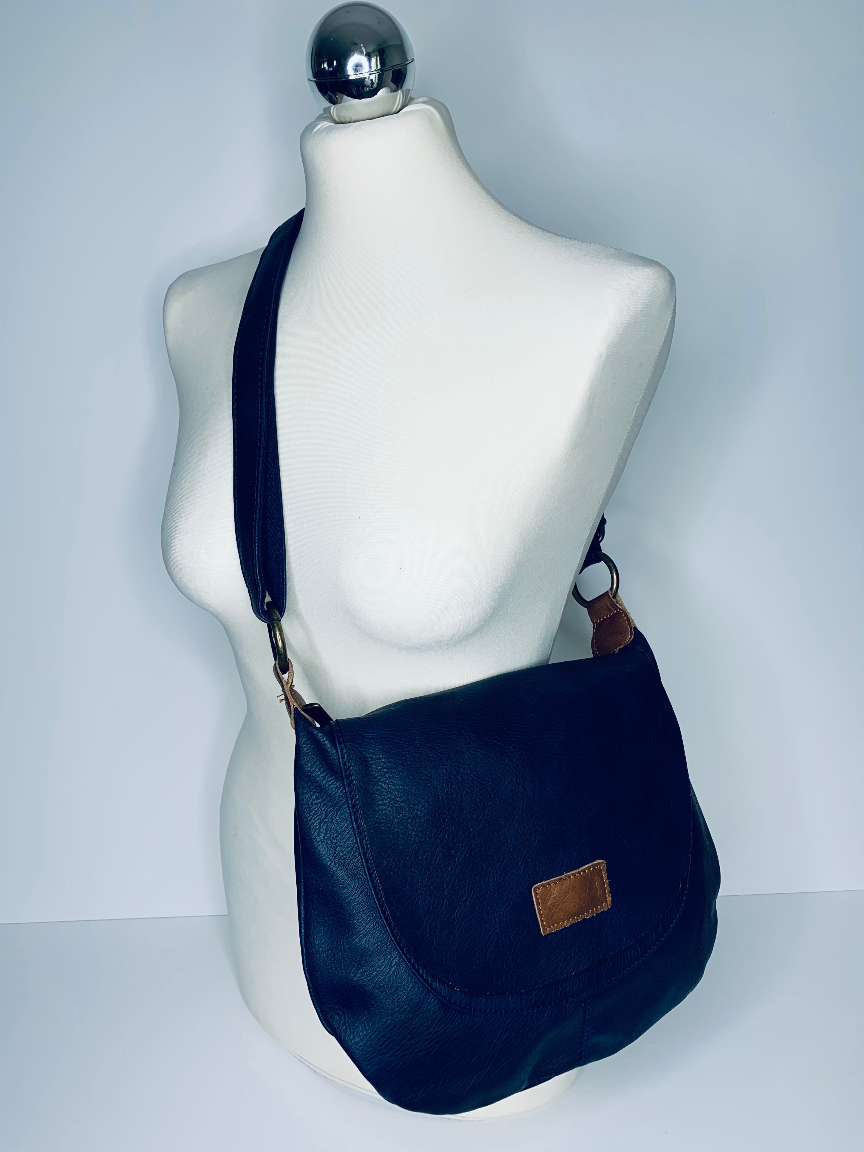 Vegan leather, cross-body round satchel bag with top zip, magnetic dot closure and adjustable strap in navy blue